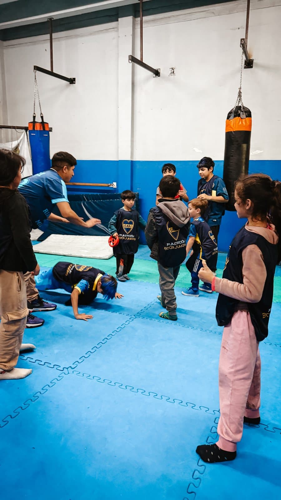 Participantes trabajando con las bolsas durante la clínica de boxeo
