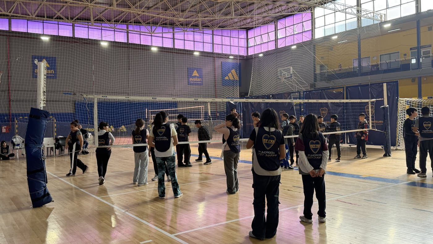 Los participantes con las pecheras de la Fundación repartidos a ambos lados de la red durante la clínica