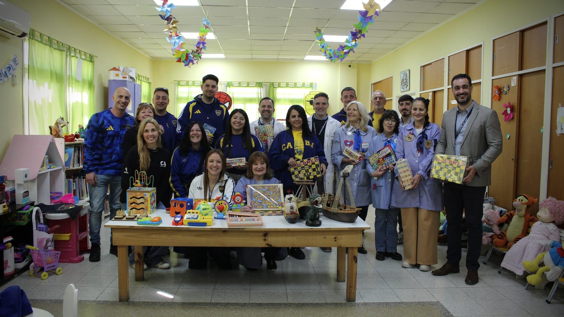 El equipo de la Fundación junto al personal del hospital, detrás de una mesa con los juguetes y juegos donados a la sala de internación