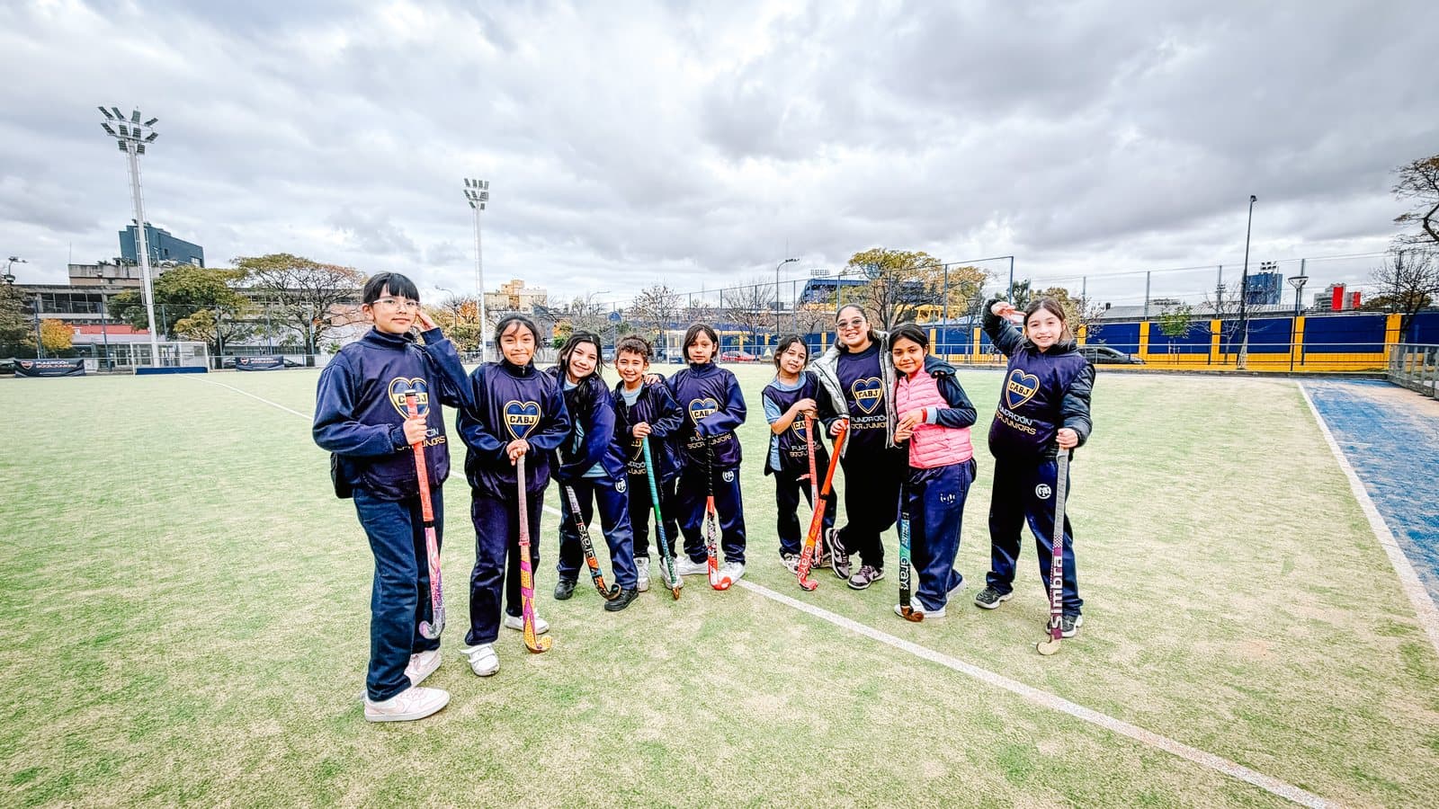 Chicos y chicas reunidos en el campo de juego del predio durante una clínica deportiva